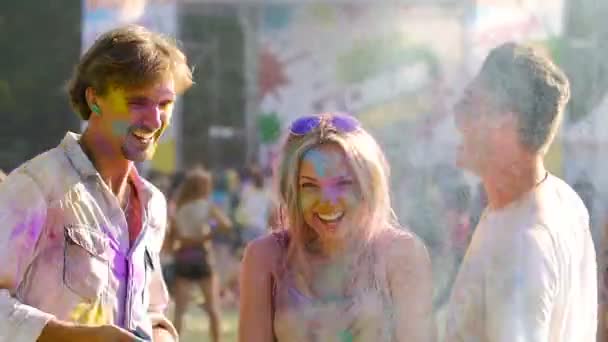 Fille jetant de la poudre colorée au-dessus de la tête, meilleurs amis dansant au festival Holi — Video