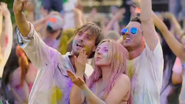 Schöne Mädchen bläst Luftküsse für die Kamera, Freunde filmen Video bei Holi Fest — Stockvideo