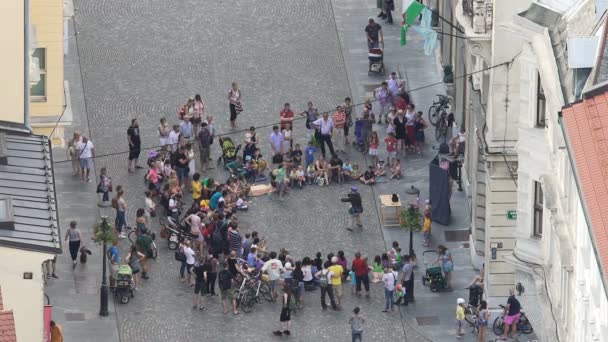 LJUBLJANA, ESLOVENIA - CIRCA JULIO 2016: La gente en la calle. Payaso actuando en la calle, multitud de personas disfrutando del espectáculo en la ciudad europea — Vídeos de Stock