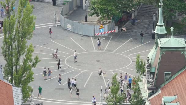 LJUBLJANA, ESLOVENIA - CIRCA JULIO 2016: La gente en la calle. Pequeña plaza de la ciudad europea, gente caminando, montando en bicicleta — Vídeos de Stock