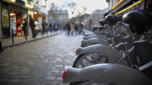 Servicio de alquiler de bicicletas, personas caminando por la calle y relajándose después del día de trabajo — Vídeo de stock