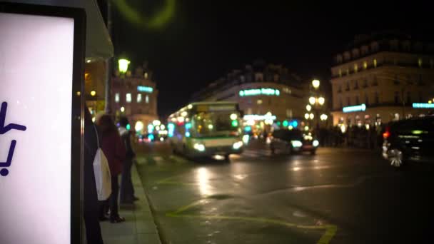 Menschen, die an Bushaltestellen auf öffentliche Verkehrsmittel warten, städtisches Leben, abends — Stockvideo