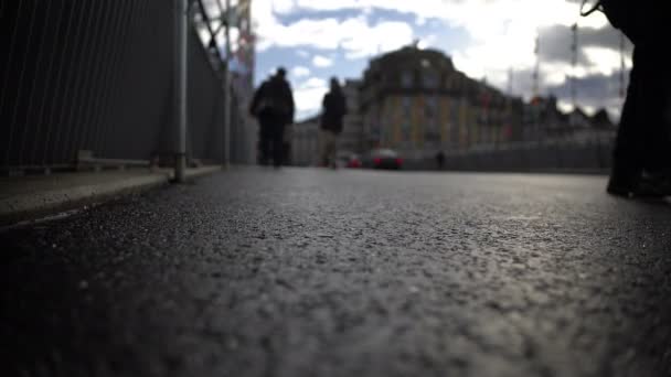 Ludzie chodzą przez most, widok zbliżenie stóp na asfalcie, miejskie życie — Wideo stockowe