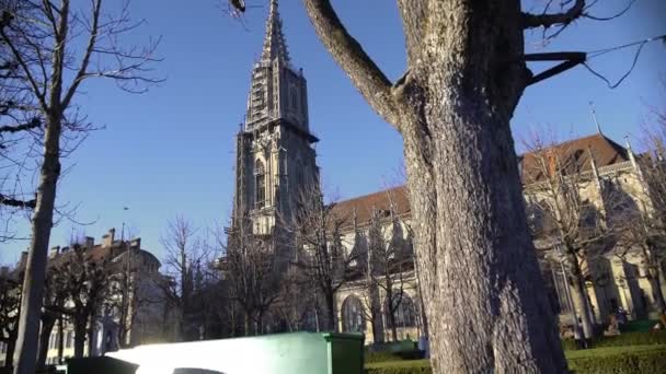 Banco vazio na bela praça perto da antiga catedral de Berna Minster, dia ensolarado — Vídeo de Stock