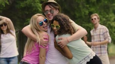 Sarılma, neşeli genç arkadaşlar kameraya bakarak, parti, dans yavaş hareket