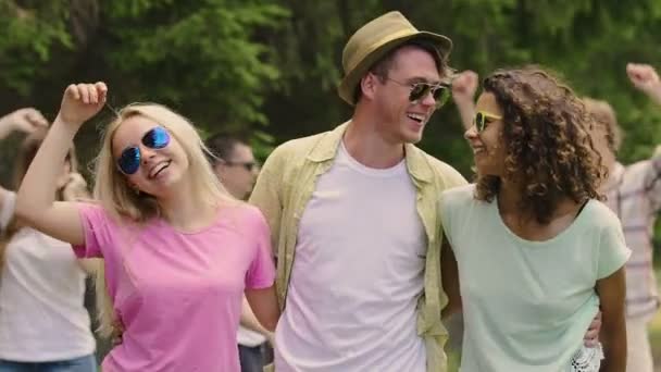 Молодой человек танцует и флиртует с красивыми дамами, летняя вечеринка на открытом воздухе — стоковое видео