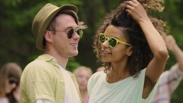 Slowmotion of young couple in sunglasses smiling to camera, happy people hugging — Stock Video