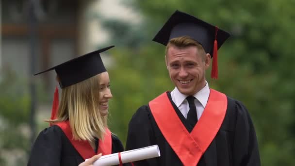 Unga vackra akademiker skratta med diplom i händerna, framgångsrik framtid — Stockvideo