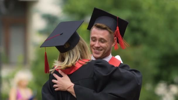 Para absolwentów, cieszyć się życiem, przytulanie i odwracając, prawdziwe szczęście — Wideo stockowe