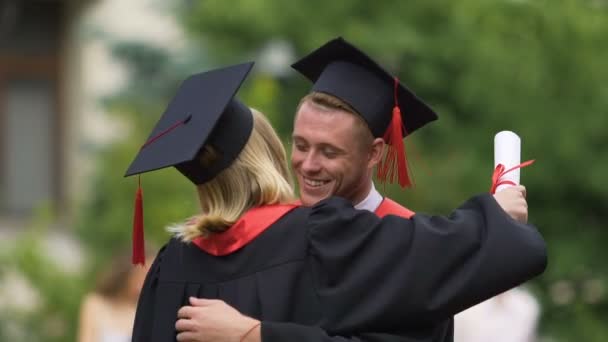 Szczęśliwe pary absolwentów razem, chłopak przewożący dziewczyna i przędzenia, miłość — Wideo stockowe