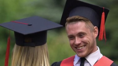 Yakışıklı erkek mezunu genç bir bayanla, komik öğrenci hayatı kutlamanın flört