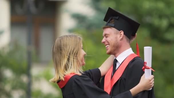 Tierna mujer graduada bromeando y riendo con su novio, celebrando el éxito — Vídeos de Stock