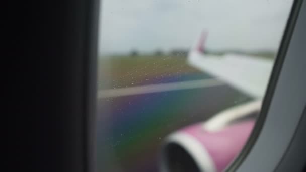 Plane wing and engine seen through rainy window during shaky landing on runway — Stock Video