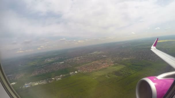 Фотография пассажира рейса, выглядывающего из окна на землю, небо и крыло самолета — стоковое видео