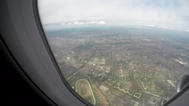 Large city seen through window of plane flying high in sky, air travel service — Stock Video