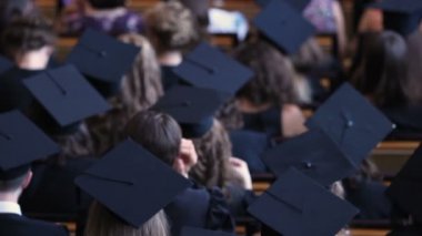 Akademik giysi töreni ödüllendirme diploma izlerken erkek ve kadın mezunları