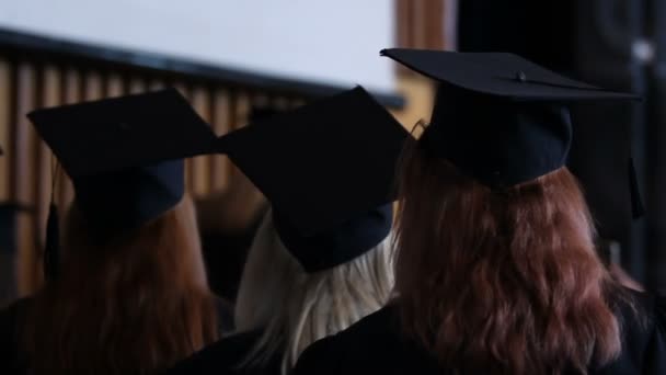 Framgångsrika unga kvinnor förbereder sig för att ta emot diplom vid examensceremoni — Stockvideo