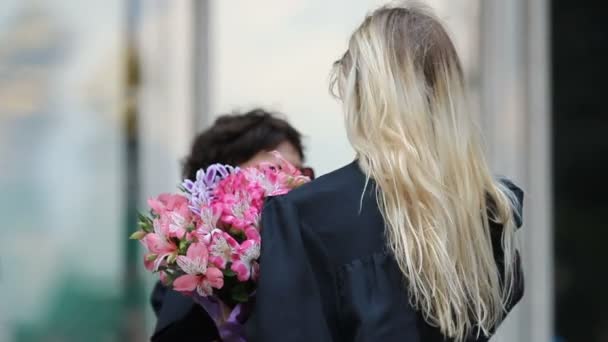 Blonde Dame erhält Blumen und Glückwünsche zum Universitätsabschluss — Stockvideo