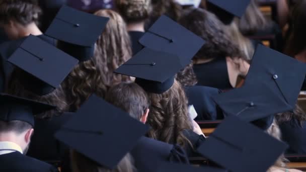 Arkadan görünüş mezun öğrenciler akademik kapaklar, diploma verilmesi töreni — Stok video