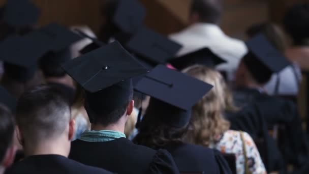 Φοιτητές και γονείς βλέποντας επίσημη γιορτή αποφοίτησης, εκπαίδευση — Αρχείο Βίντεο