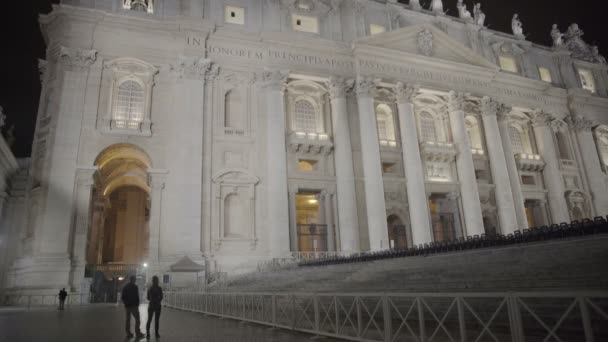 Пара туристов, наслаждающихся ночным видом на освещенную базилику Святого Петра — стоковое видео