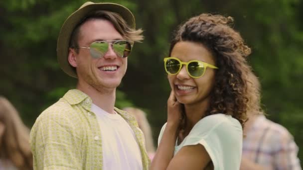 Joven pareja sonriente mirando a la cámara, disfrutando de fin de semana de verano con amigos — Vídeos de Stock