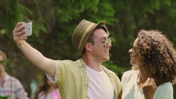 Felices amigos multiculturales tomando selfie, sonriendo para la cámara en la fiesta al aire libre — Vídeos de Stock