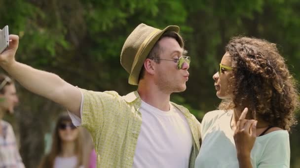 Mladá žena a muž baví, pořízení selfie na letní hudební festival — Stock video