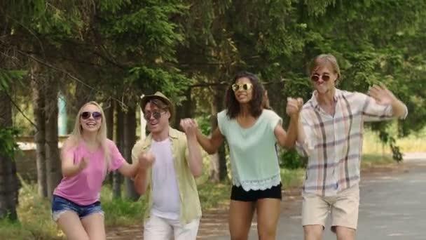 Mädchen und Jungs halten Händchen und springen auf Outdoor-Party, feiern das Leben — Stockvideo