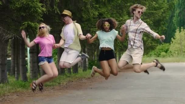 Mujeres y hombres jóvenes y felices saltando, bailando música en la fiesta al aire libre, juventud — Vídeos de Stock