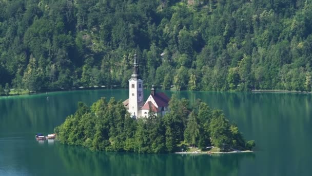Isla aislada con iglesia rodeada por el lago Bled y los Alpes, espiritualidad — Vídeo de stock