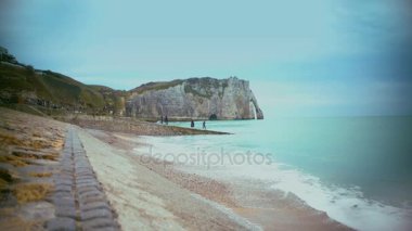 Ünlü Etretat kayalıklardan yakınındaki kıyısında yürüyüş ve güzel manzarayı turist