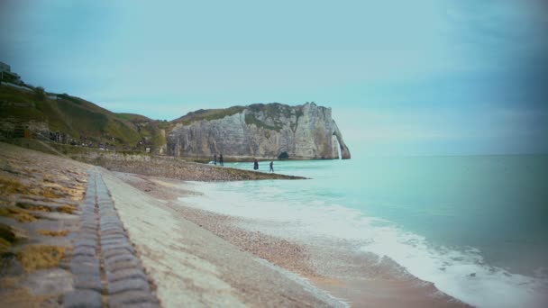 Turistas caminando por la costa cerca de famosos acantilados de Etretat y disfrutando de una hermosa vista — Vídeo de stock