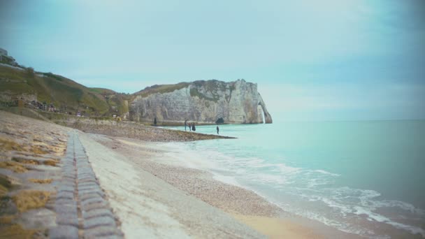 Pessoas relaxando na costa na cidade de Etretat, desfrutando de uma vista incrível da natureza — Vídeo de Stock