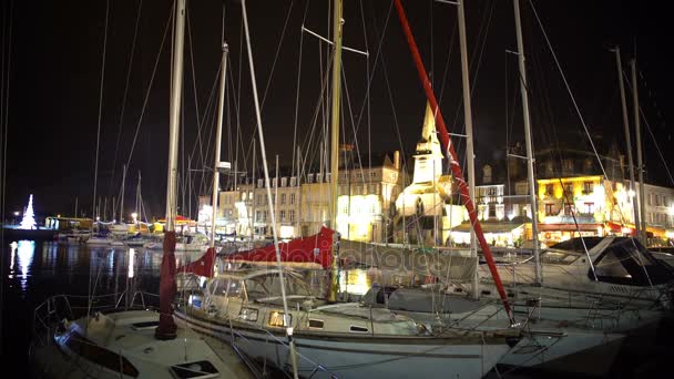 Рождественское время в уютном городке, вид на яхты и лодки, пришвартованные в гавани ночью — стоковое видео