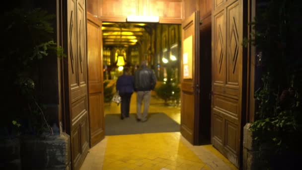 Homem e mulher entrando belo salão de igreja de madeira, culto de adoração à noite — Vídeo de Stock