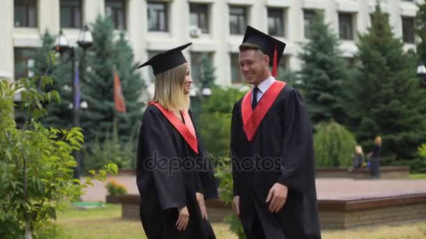 Two happy graduates relaxing in park near university and talking about future — Stock Video