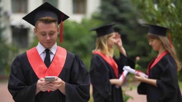 Happy graduate uploading photos from ceremony to social network, memorable event — Stock Video