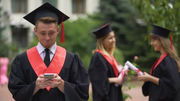 Graduate checking job offers on smartphone, reading messages in social network — Stock Video