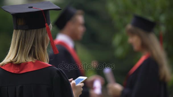 Smartphone ve mezuniyet töreni sonrası rahatlatıcı kadın lisansüstü manifatura — Stok video