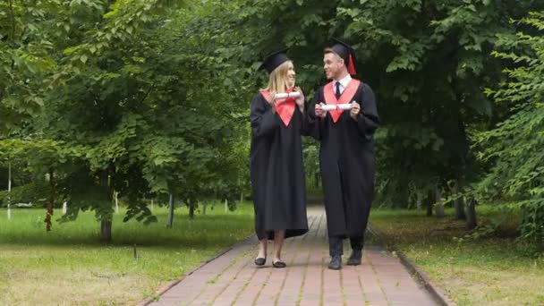 Heureux couple de diplômés aller de l'avant et parler de l'avenir, l'obtention du diplôme — Video