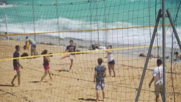 Jovens desfrutando de jogo de vôlei na praia arenosa, esporte de equipe para amigos — Vídeo de Stock