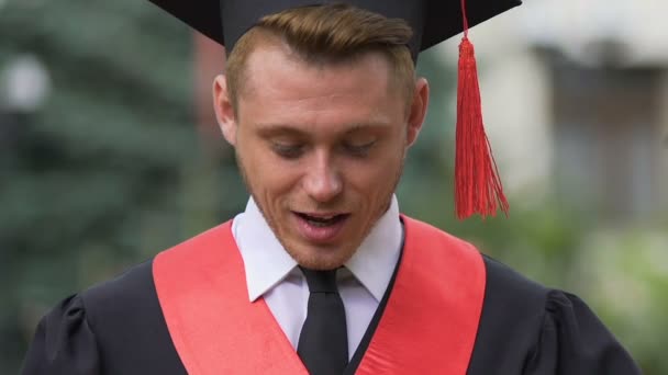 Meglepett férfi diplomás nézett le a mosoly az arcán, karrierlehetőség — Stock videók