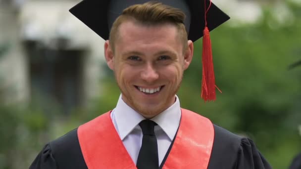 Rosto sorridente de graduado universitário masculino olhando para câmera, estudante de sucesso — Vídeo de Stock