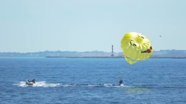Tourists parasailing over sea, feet touching water, extreme sport, summer fun — Stock Video