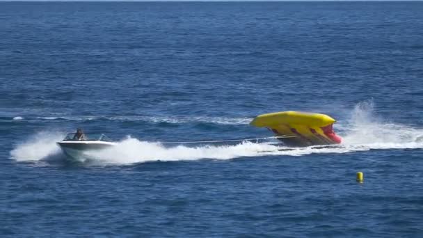 Tourists floating on waves on banana boat, summer holidays, cool entertainment — Stock Video