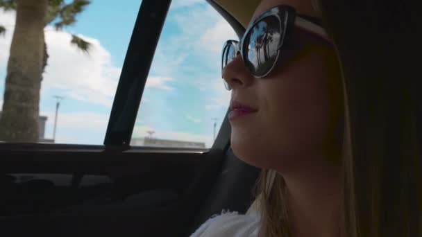 Nette Frau mit Sonnenbrille genießt den Blick auf den Strand durch das Autofenster, Taxiservice — Stockvideo