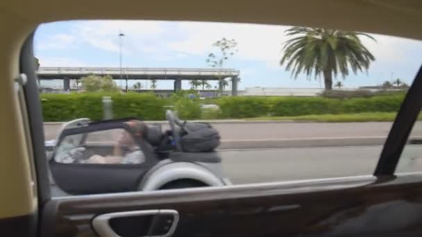 Luxusní resort city, výhled z okna auta na ulici s palmami a drahá auta