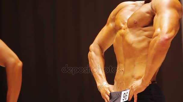 Schlanker Mann mit idealem Sixpack Bauchmuskeln bei Bodybuilding-Wettbewerb, Lat-Pose vorne — Stockvideo