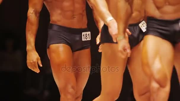 Бодибилдеры мужского пола выходят на сцену, чтобы показать сильные мускулистые тела на соревнованиях — стоковое видео